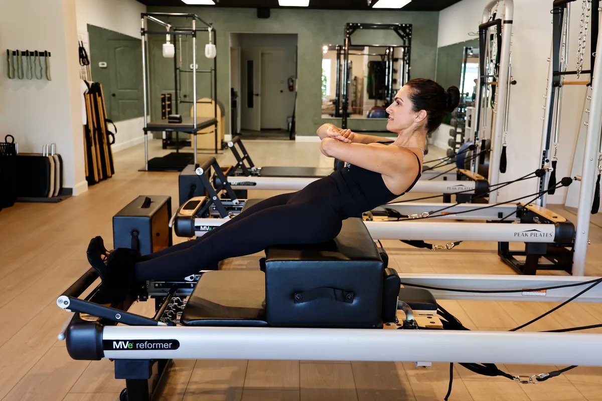 Client working through a controlled Reformer exercise during a private session