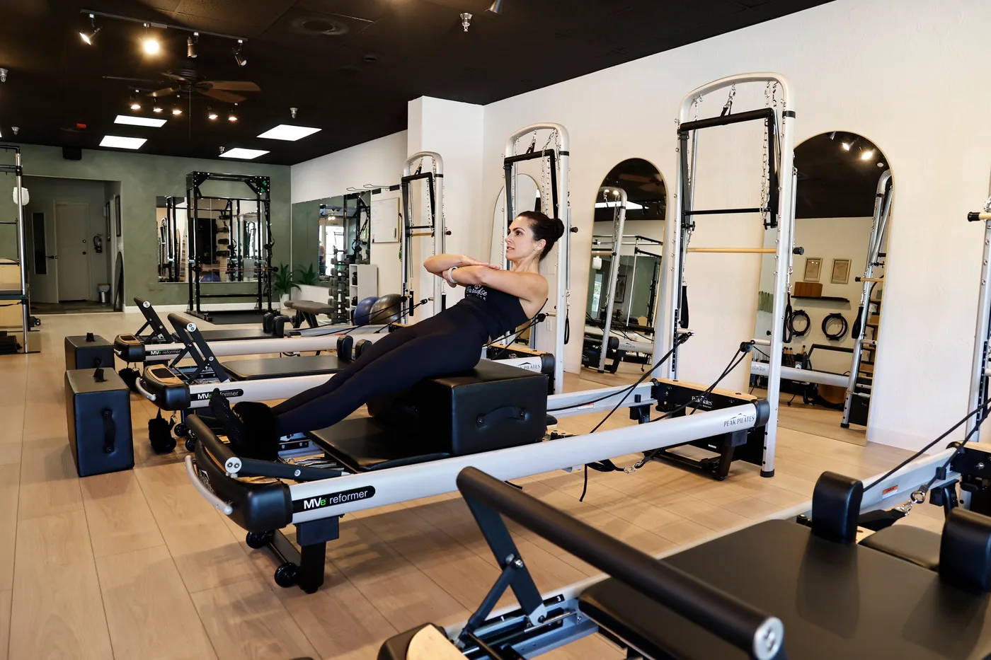 Reformers lined up on the studio floor at Paradise Pilates during a class