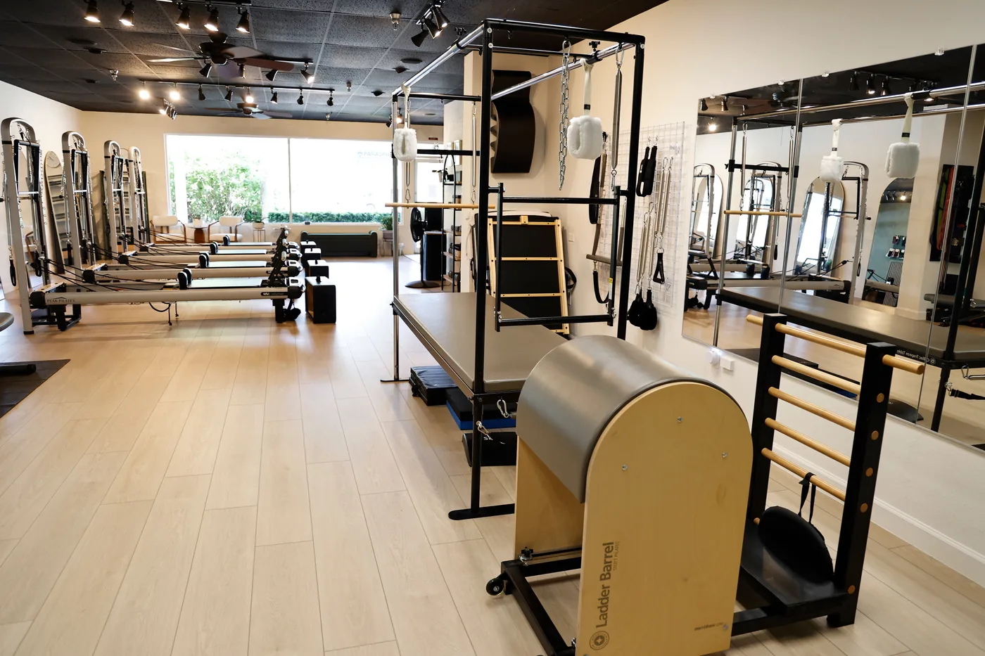 The Paradise Pilates studio floor with reformers, a Cadillac tower, and a ladder barrel